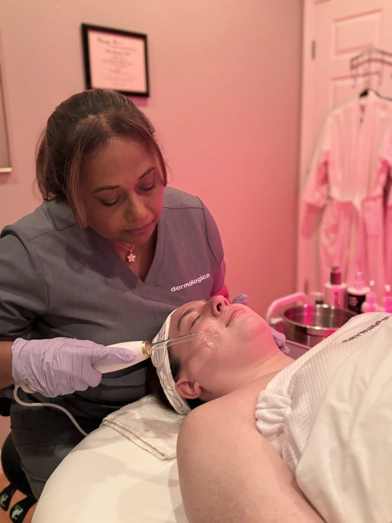 A woman is getting her face cleaned by an esthetician.